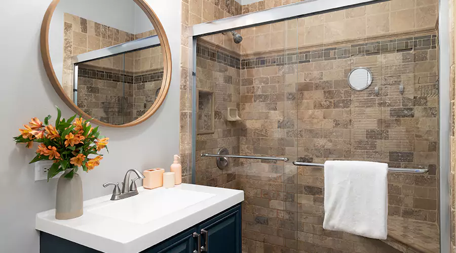 Modern bathroom renovation featuring a light wood vanity, matte black fixtures, and a glass shower enclosure